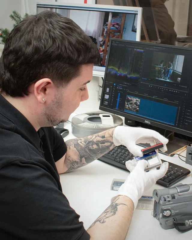 Técnico preparando cintas MiniDV para su digitalización junto a la cámara